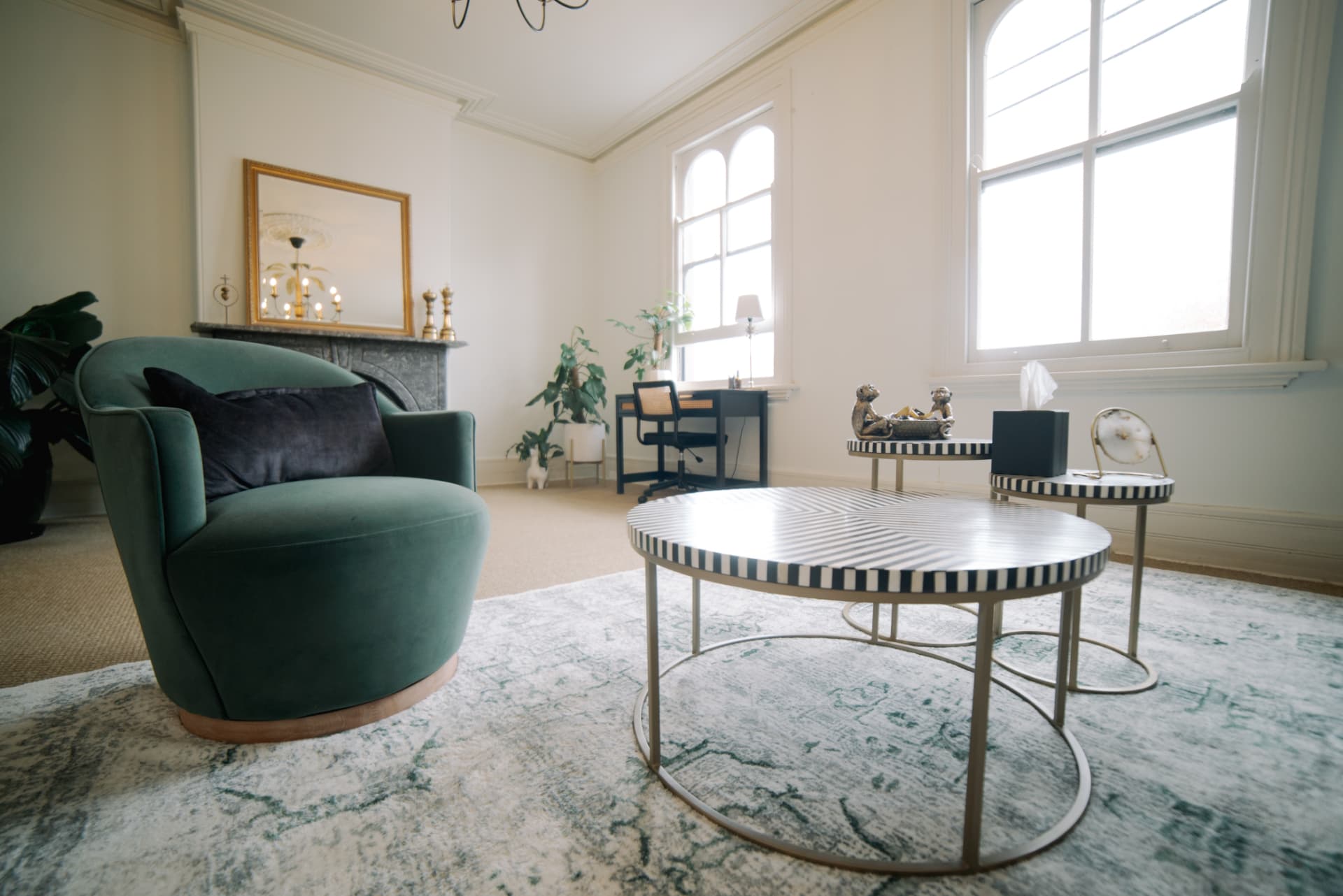 A comfortable therapy room with a green velvet armchair and natural light