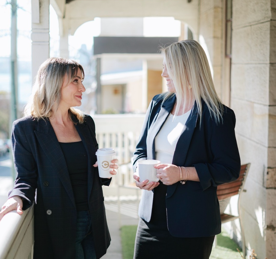 Two therapists talking together on the Balmain East balcony